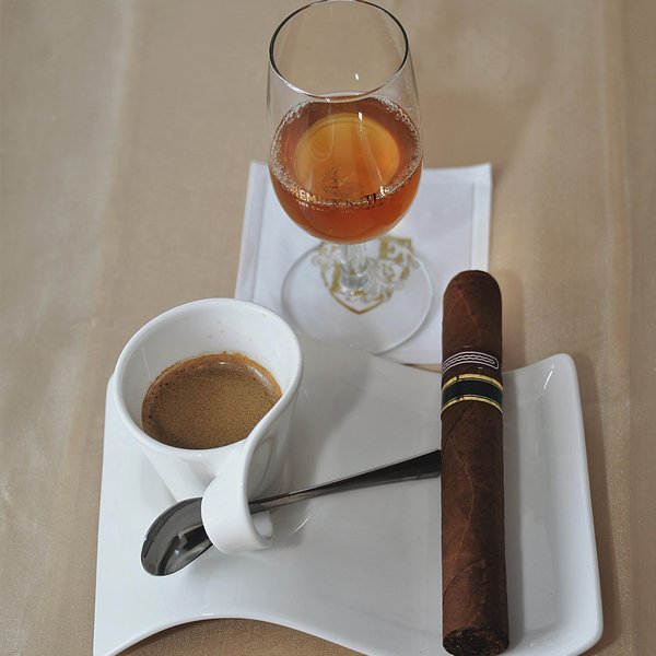 Kaffetasse, Zigarre und Glas mit Likör auf einem Tisch