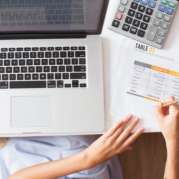 Das Bild zeigt einen Laptop und einen Taschenrechner