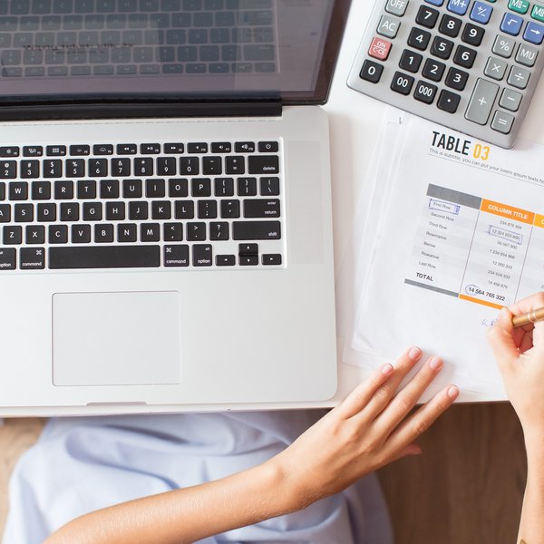 Das Bild zeigt einen Laptop und einen Taschenrechner