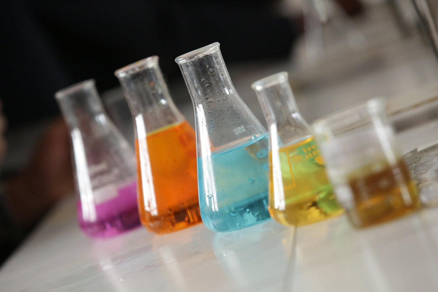 Das Bild zeigt verschiedene Gefäße mit Chemikalien in einem Labor.