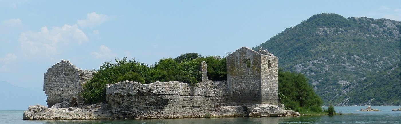 Das Bild zeigt eine Aufnahme des Skutarisees in Montenegro mit einer kleinen Insel.