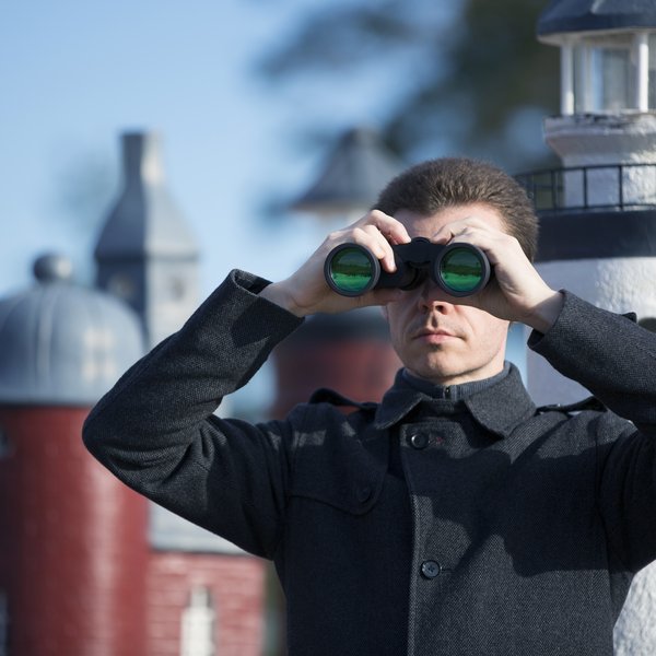 Das Bild zeigt einen Mann mit Fernglas