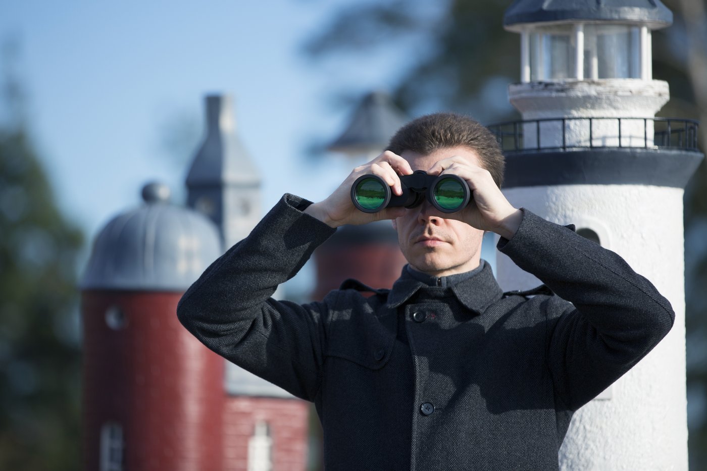 Das Bild zeigt einen Mann mit Fernglas