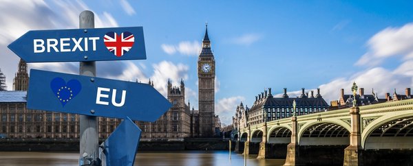 Das Bild zeigt das Parlamentsgebäude mit dem Big Ben in London. Im Vordergrund sieht man zwei Schilder mit den Aufschriften EU und Brexit. Beide zeigen in unterschiedliche Richtungen.