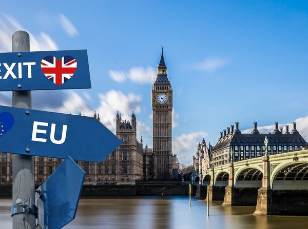 Das Bild zeigt das Parlamentsgebäude mit dem Big Ben in London. Im Vordergrund sieht man zwei Schilder mit den Aufschriften EU und Brexit. Beide zeigen in unterschiedliche Richtungen.