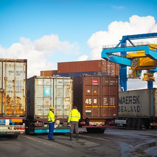 Das Bild zeigt mehrere Container auf LKWs.