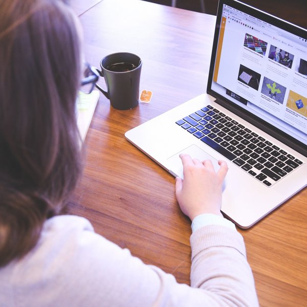 Frau, die am Laptop sitzt und arbeitet